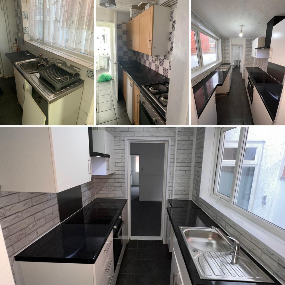 A galley kitchen with black worktops and a stainless steel sink